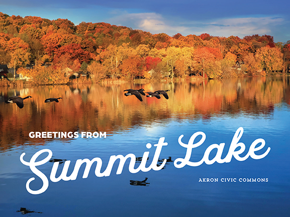 A flock of geese fly over Summit Lake with trees sporting fall foliage in the background and reflected in the water. The words, "Greetings from Summit Lake - Akron Civic Commons" is graphically laid over the image in a postcard designed style.